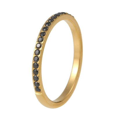 טבעת זהב עם אבנים שחורות על רקע לבן